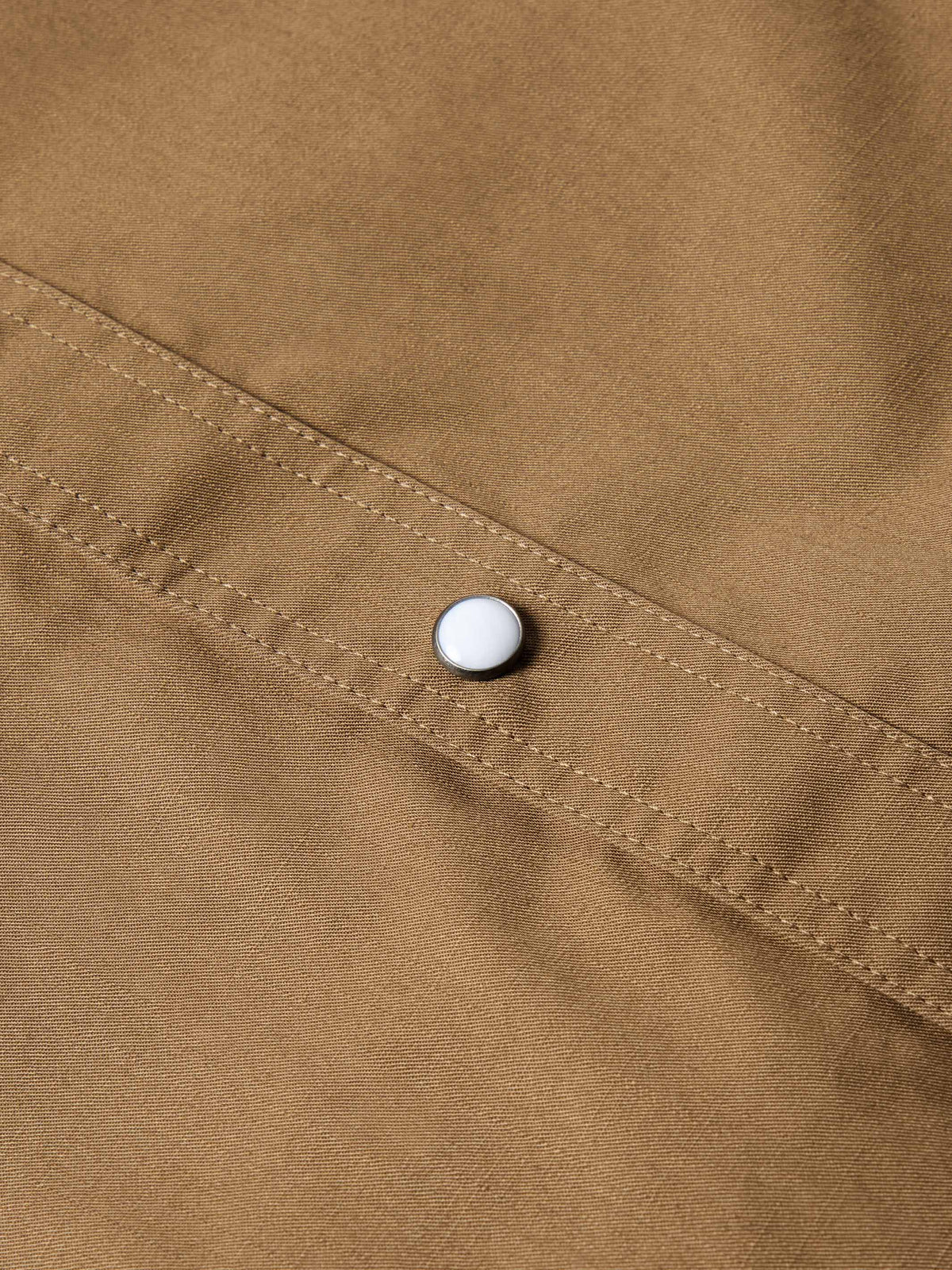 Walnut slub twill shirt fabric with a small white snap button