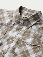Close-up of collar and front pearl snaps on tan and white plaid shirt