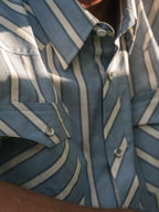 Close-up of blue and white striped western shirt with metal pearl snap buttons