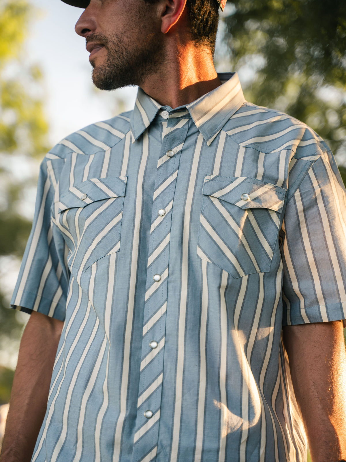 Blue and white striped short-sleeve pearl snap shirt with chest pockets and collar