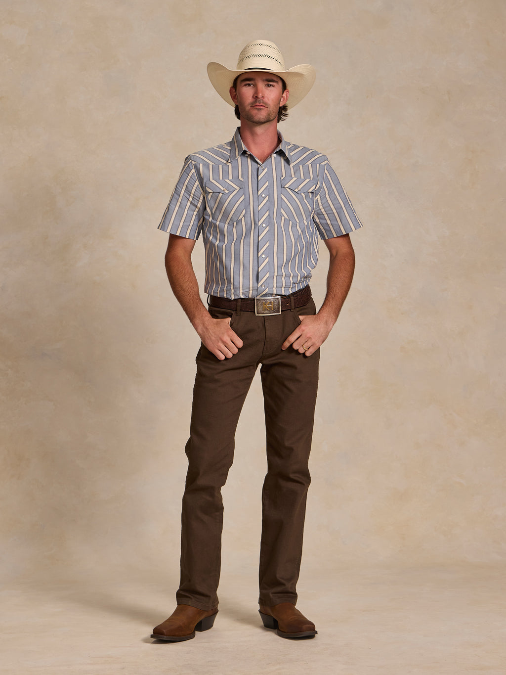 Blue-and-white striped short-sleeve pearl snap shirt worn with brown pants