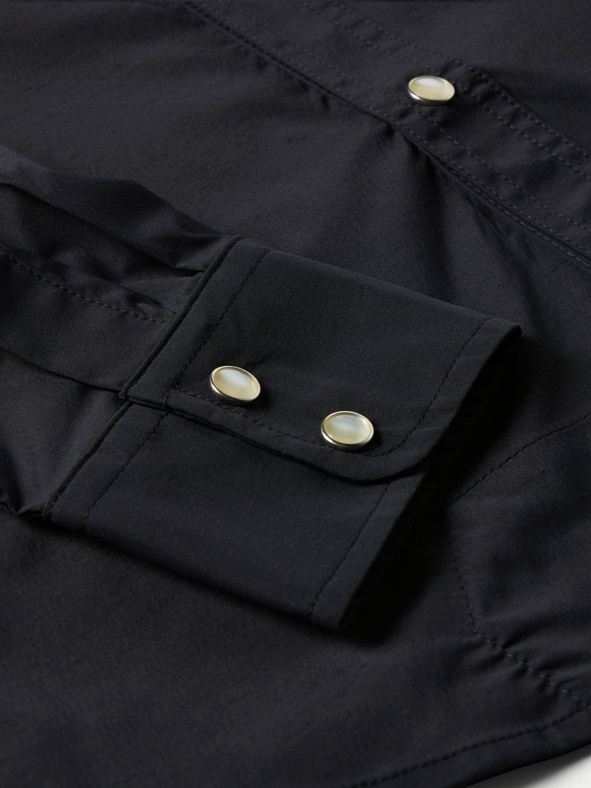 Black western snap shirt close-up of elbow-side tab with metal snap buttons