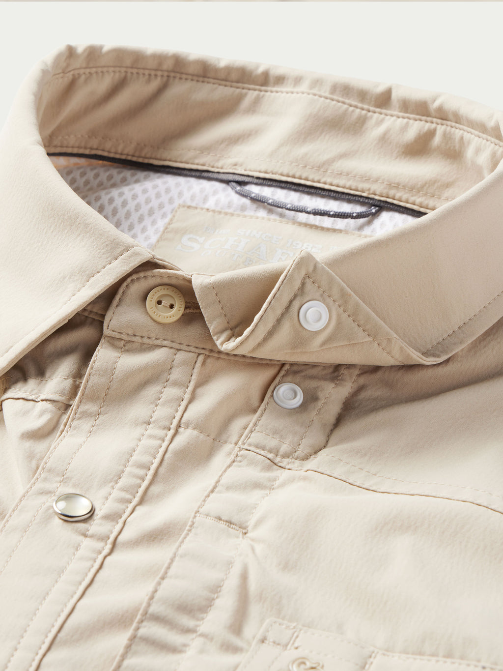 Khaki western snap shirt placket with snap tabs and reinforced pocket stitching