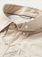 Khaki western snap shirt placket with snap tabs and reinforced pocket stitching