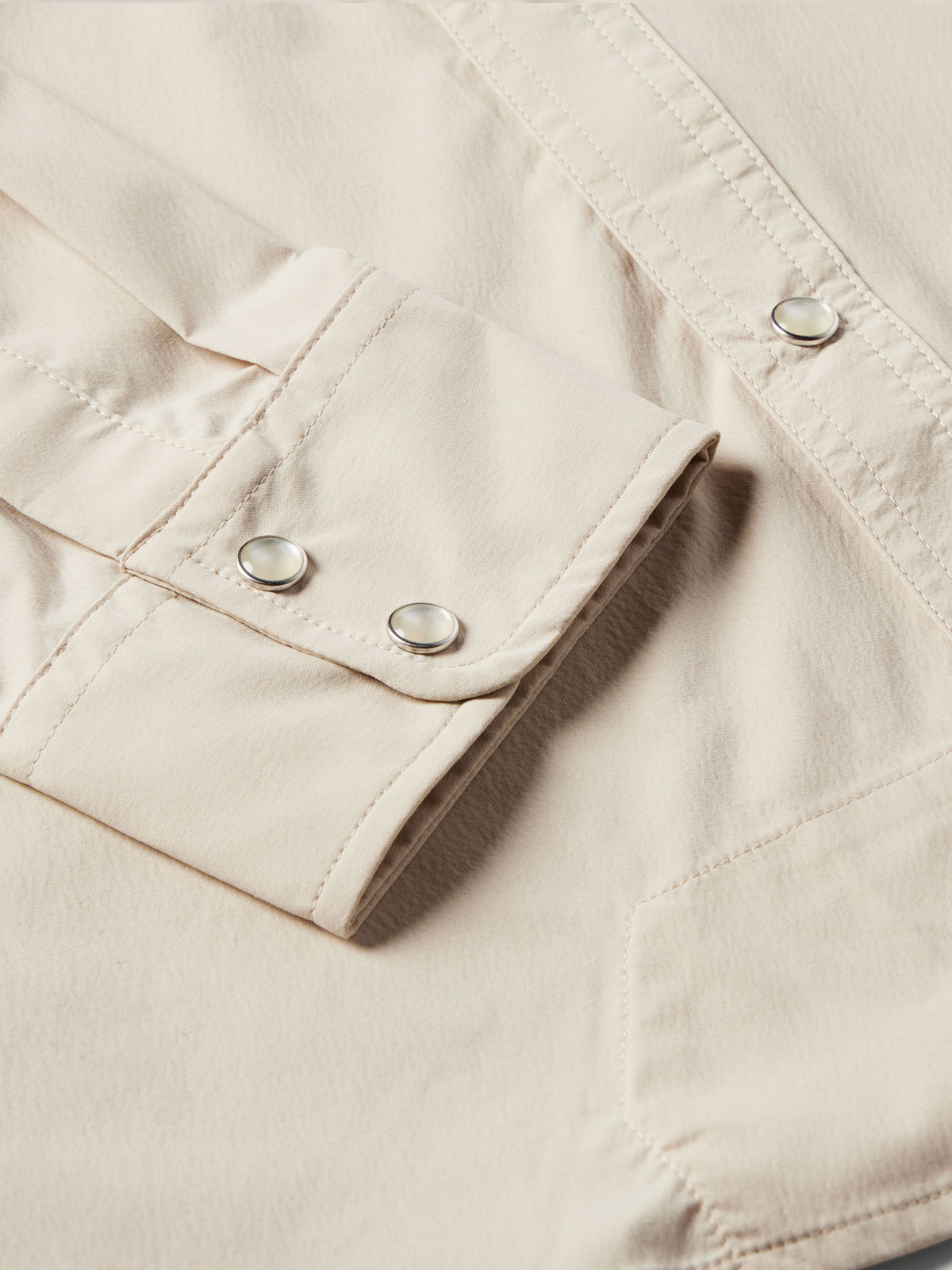 Khaki shirt cuff and sleeve placket with two button snaps and stitched trim