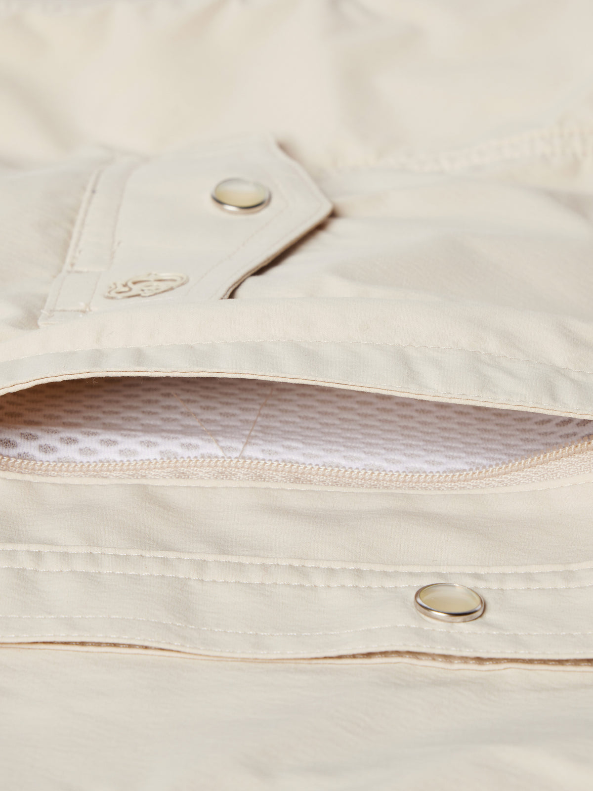 Khaki snap shirt pocket flap detail with metal ring snap and inner fabric lining