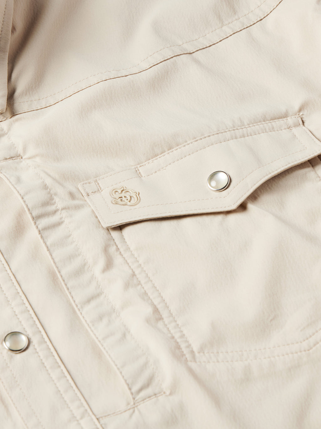 Khaki snap shirt chest pocket placket with embroidered emblem and metal snap button