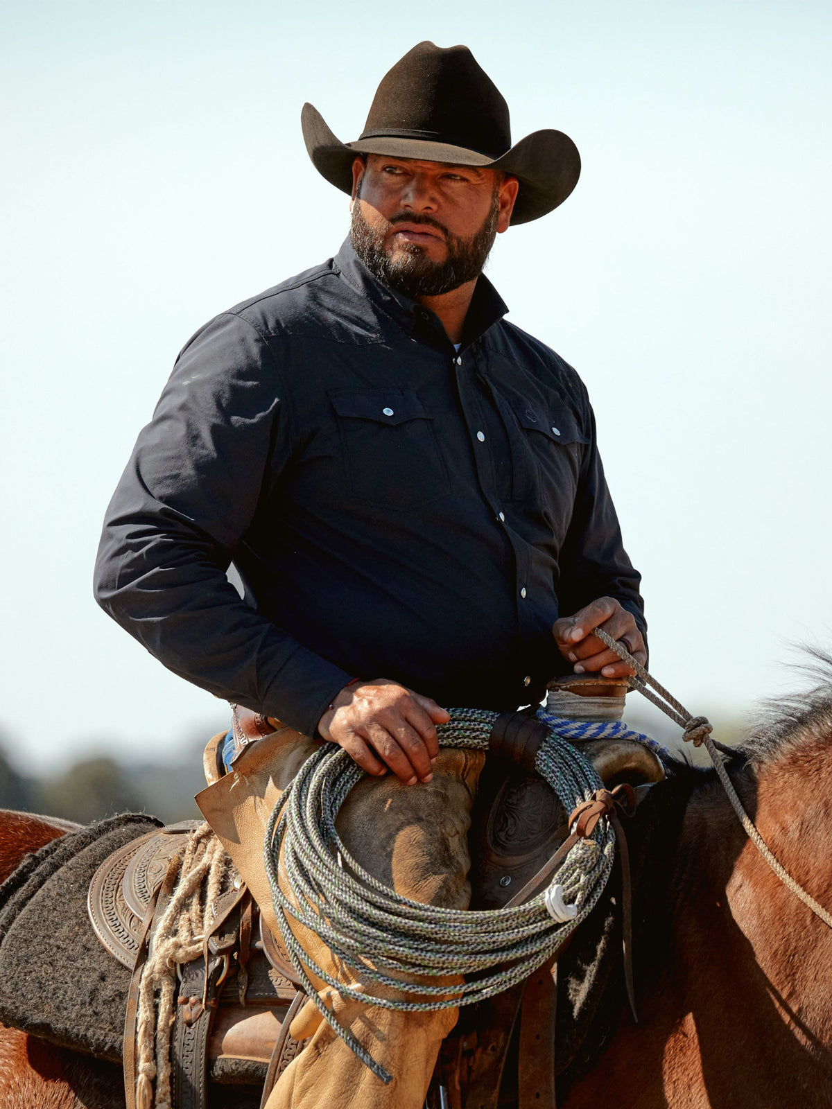 Black western snap shirt on a person, long sleeves with button-front closure