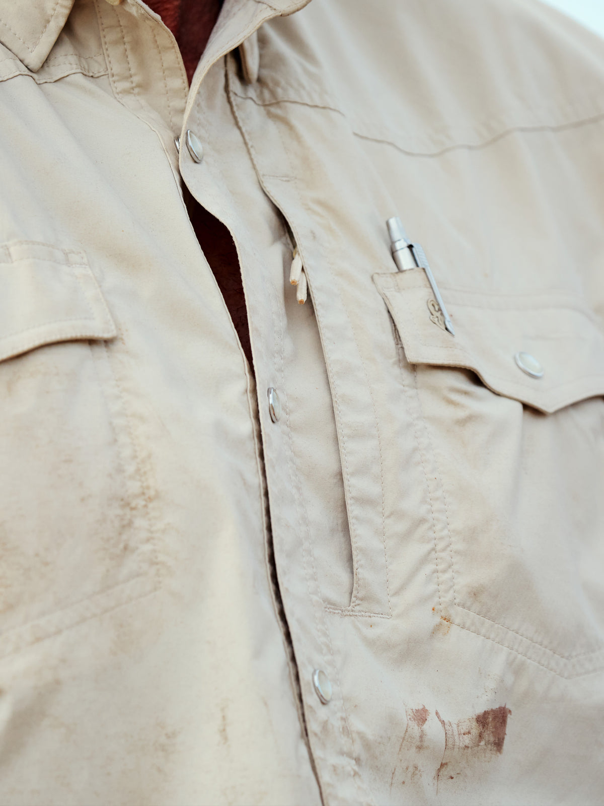 Khaki western snap shirt showing chest pocket and buttoned placket.