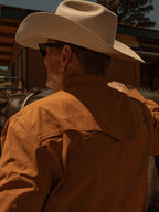 Rust western snap shirt worn by person with beige cowboy hat