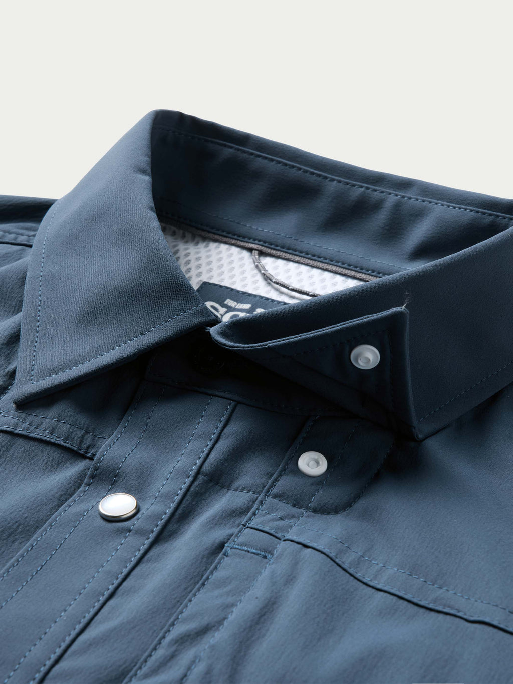 Navy snap-front western shirt with buttoned collar and chest placket close-up