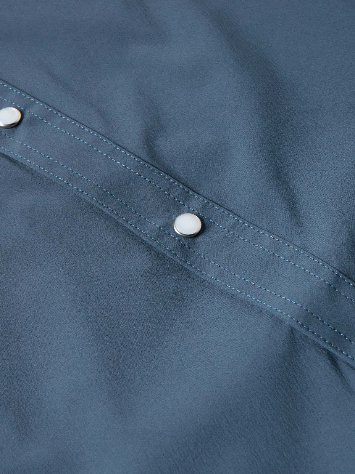 Navy western snap shirt with contrast-stitched seam and silver button
