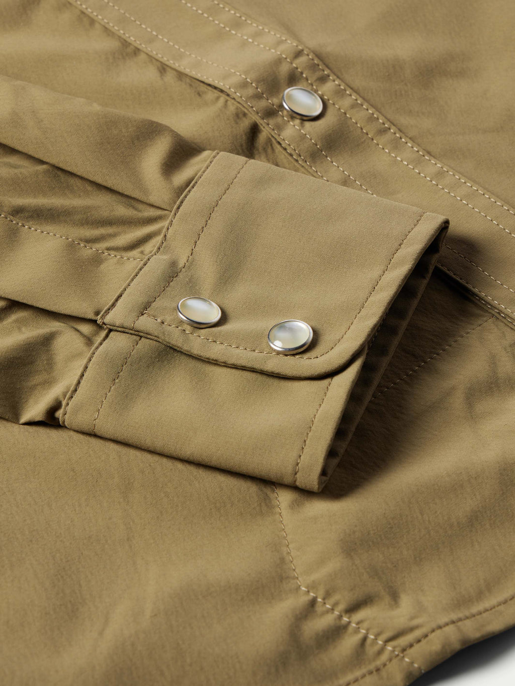Olive snap shirt sleeve cuff with two snap buttons and stitched seam