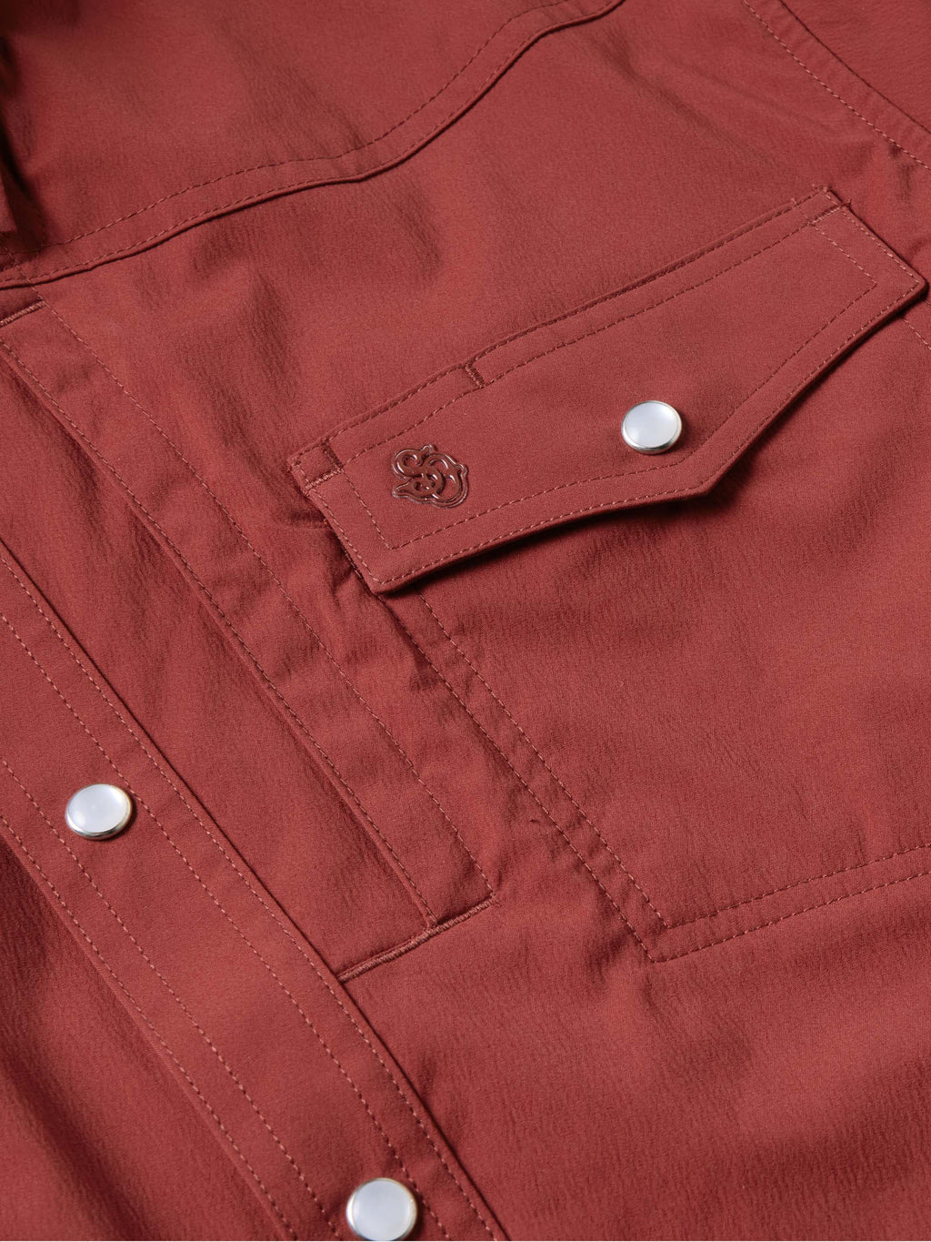 Oxblood snap pocket flap with metal snap button and visible stitching