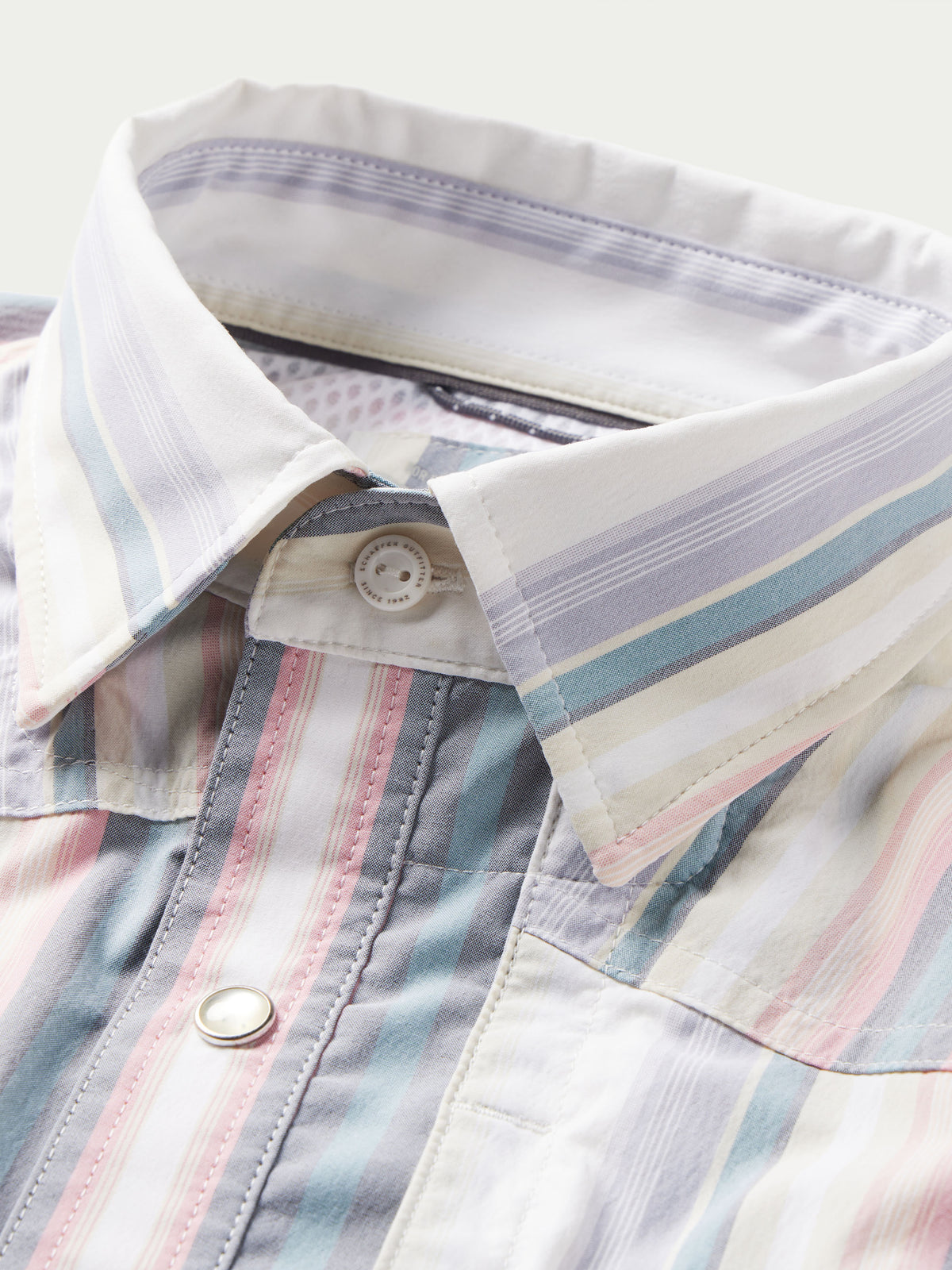 Collar and placket close-up of pastel striped western snap shirt with snap button