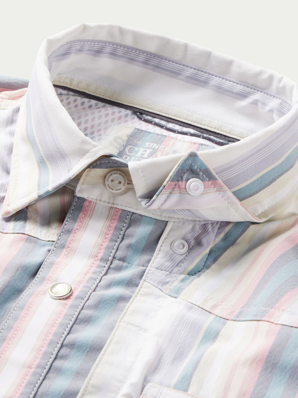 Inside collar and placket view of pastel striped western snap shirt with snap hardware