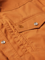 Rust snap shirt chest pocket flap with embroidered badge and snap button