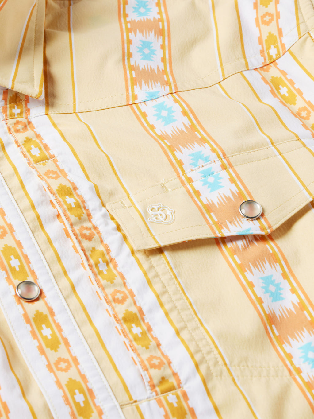 Western snap shirt neckline with dark cord detail, cream base, and orange Aztec stripes
