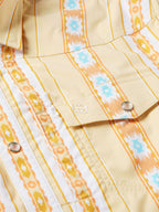Western snap shirt neckline with dark cord detail, cream base, and orange Aztec stripes