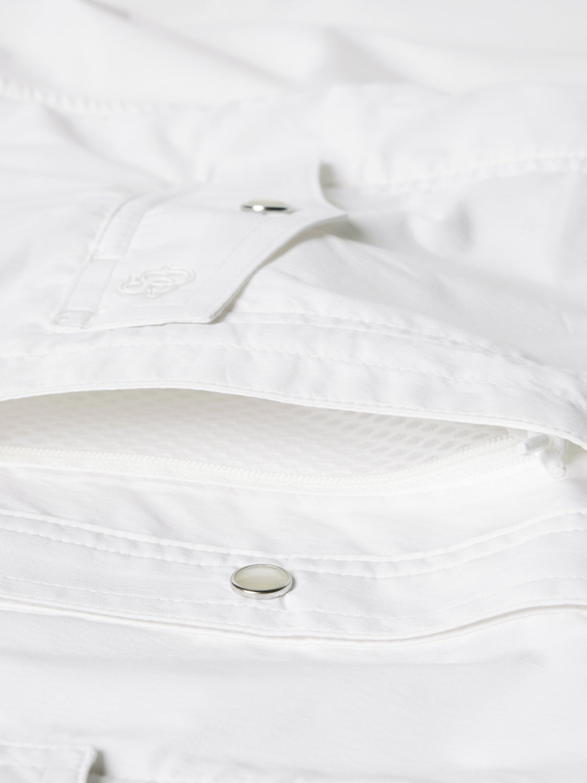 White shirt interior neckline and snap strap detail with metal snap button close-up