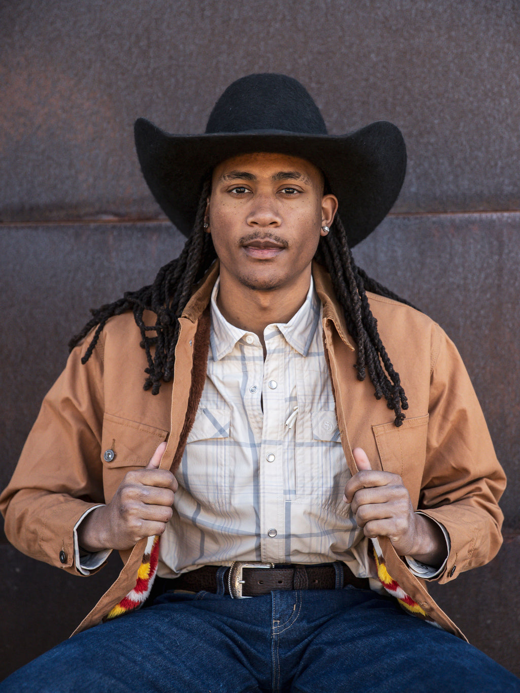 Western guide snap shirt on model, tan with light blue plaid, snap front and pockets.