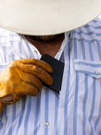Man wearing a blue and white striped Western snap shirt with flap chest pocket
