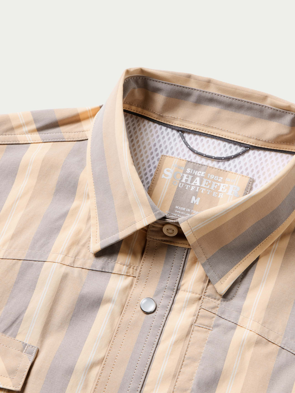 Inside collar close-up of striped snap shirt with metal snap and size label