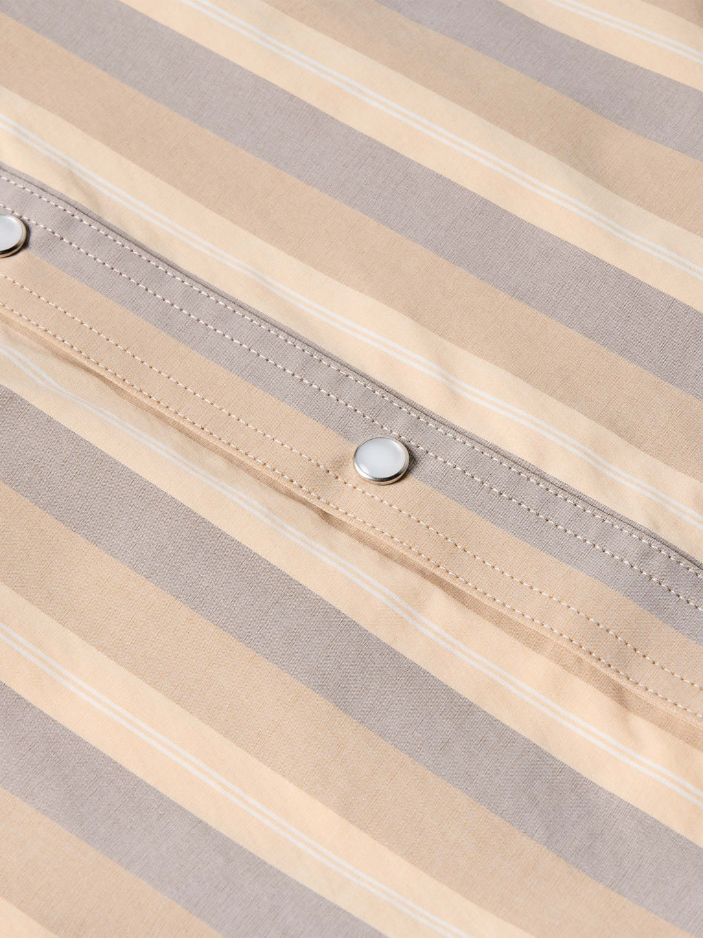 Striped snap-front western shirt placket with metal snap button and stitched accents