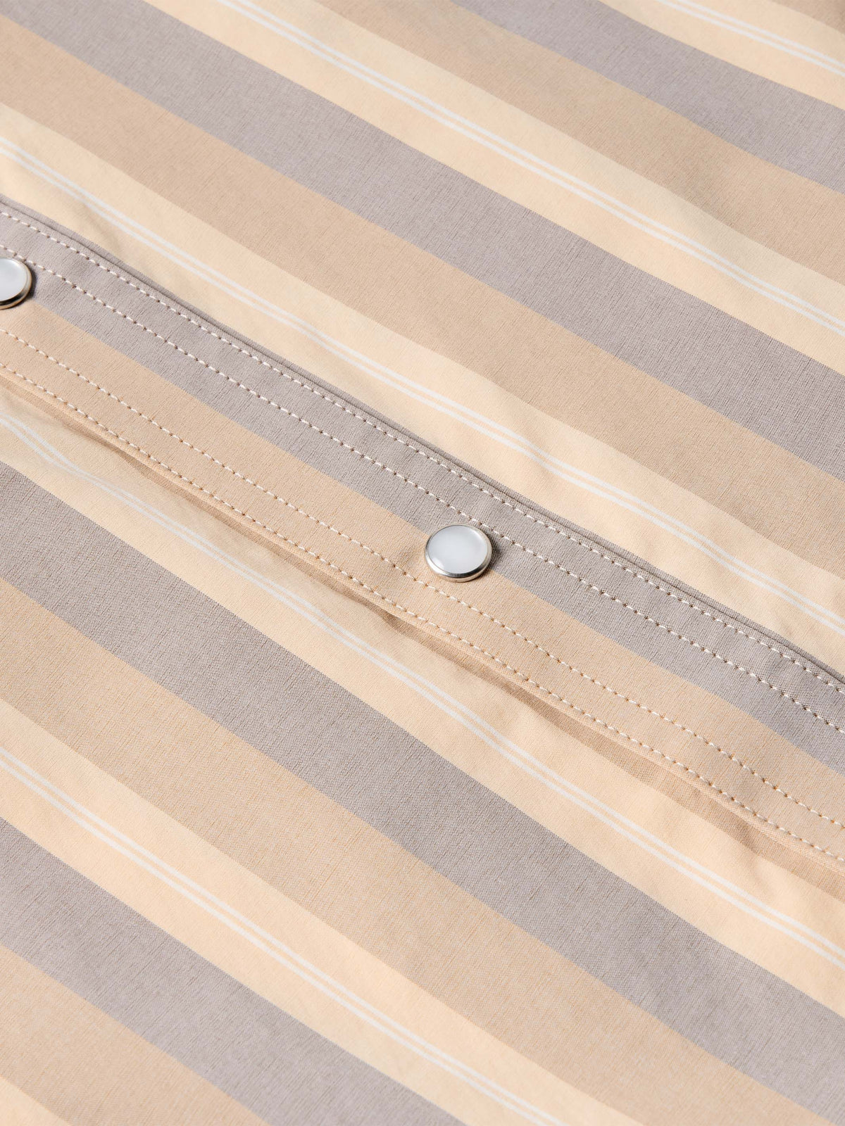 Striped snap-front western shirt placket with metal snap button and stitched accents