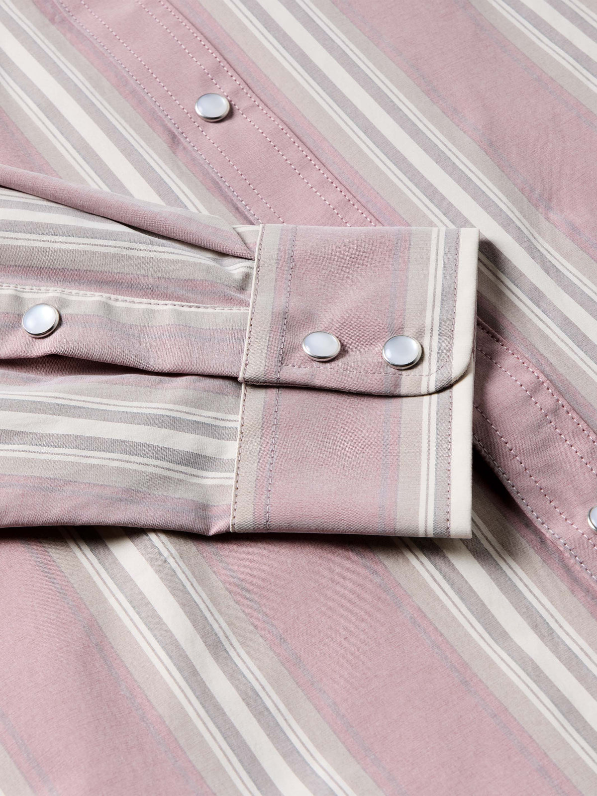 Pink striped shirt cuff and button detail with long sleeves