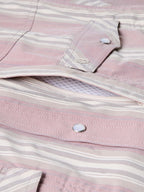 Pink striped shirt placket and button close-up with embroidered logo