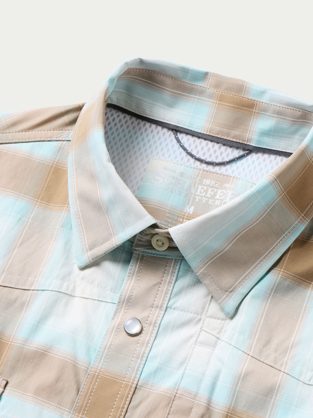 Western snap shirt neckline and chest placket in light blue and tan plaid