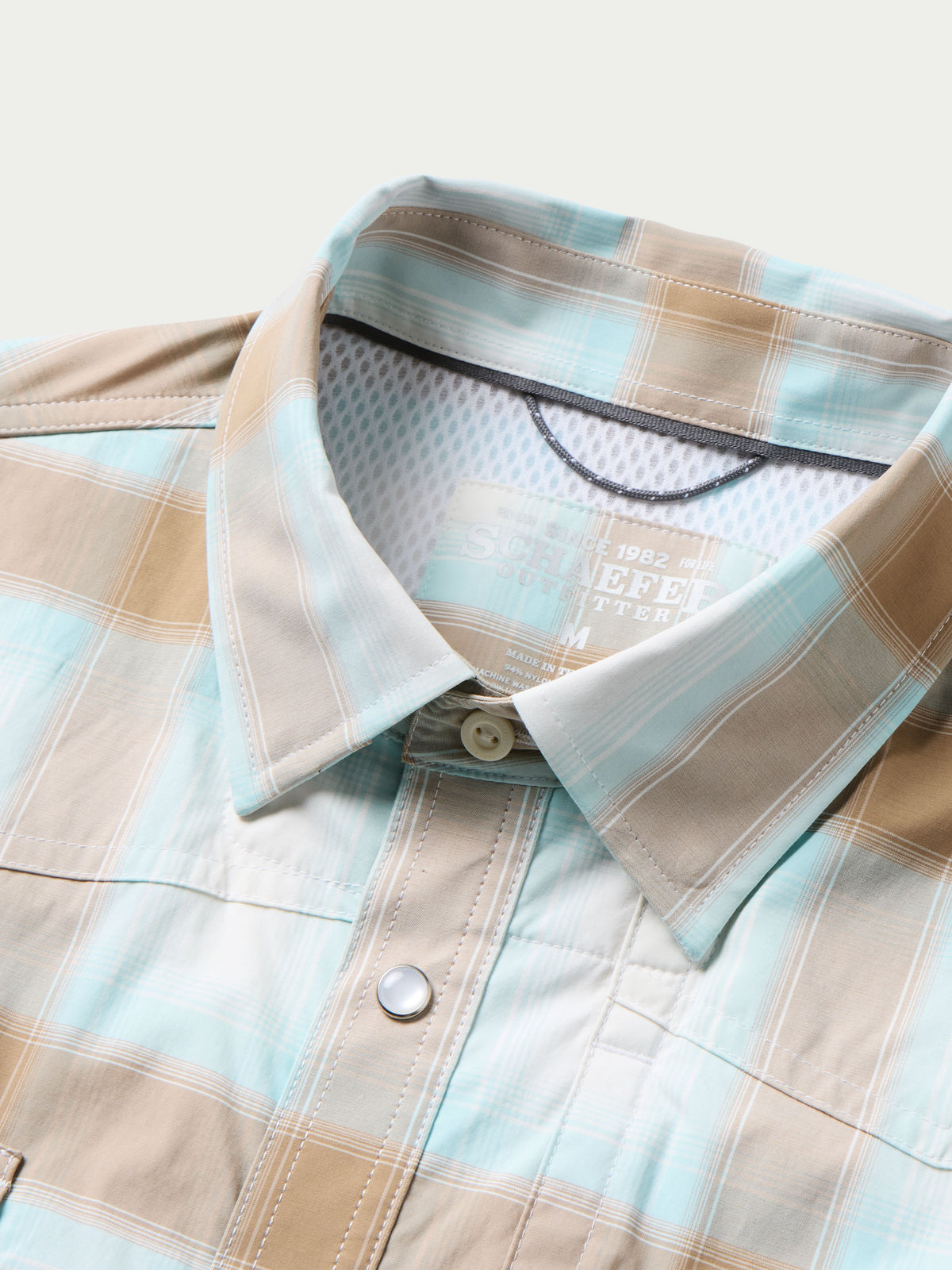 Western snap shirt neckline and chest placket in light blue and tan plaid