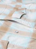 Western snap shirt front yoke and chest snap placket in light blue and tan plaid