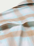 Western snap shirt sleeve in light blue and tan plaid with soft fold and stitching