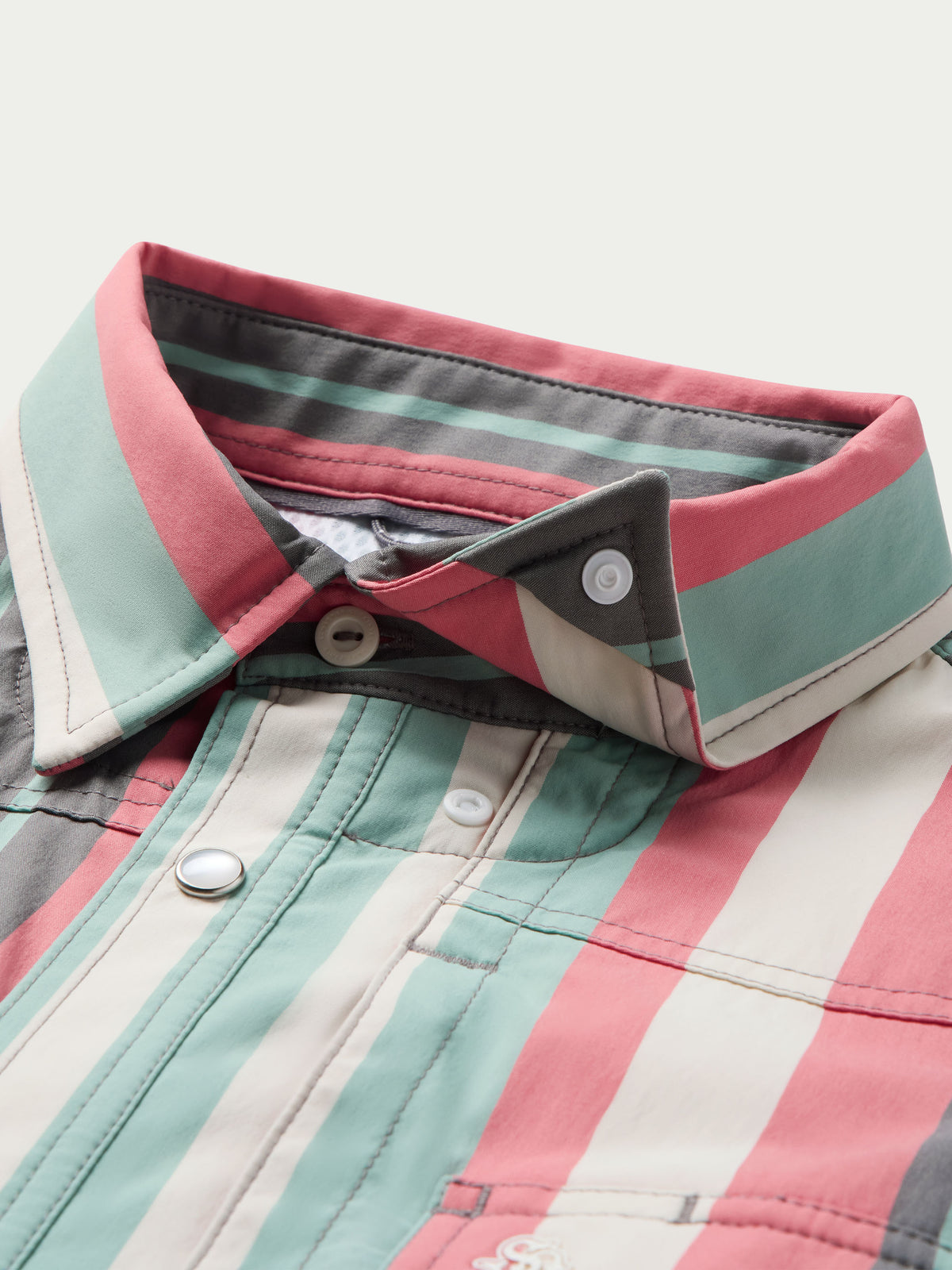 Western snap shirt collar and front placket with snaps on striped fabric.