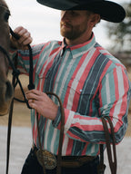 Western snap shirt with long sleeves, teal-pink-white stripes, and snap front.
