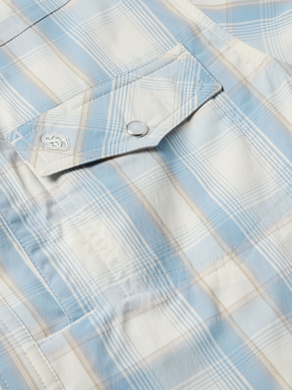 Light blue plaid western shirt shoulder yoke with embroidered emblem and snap