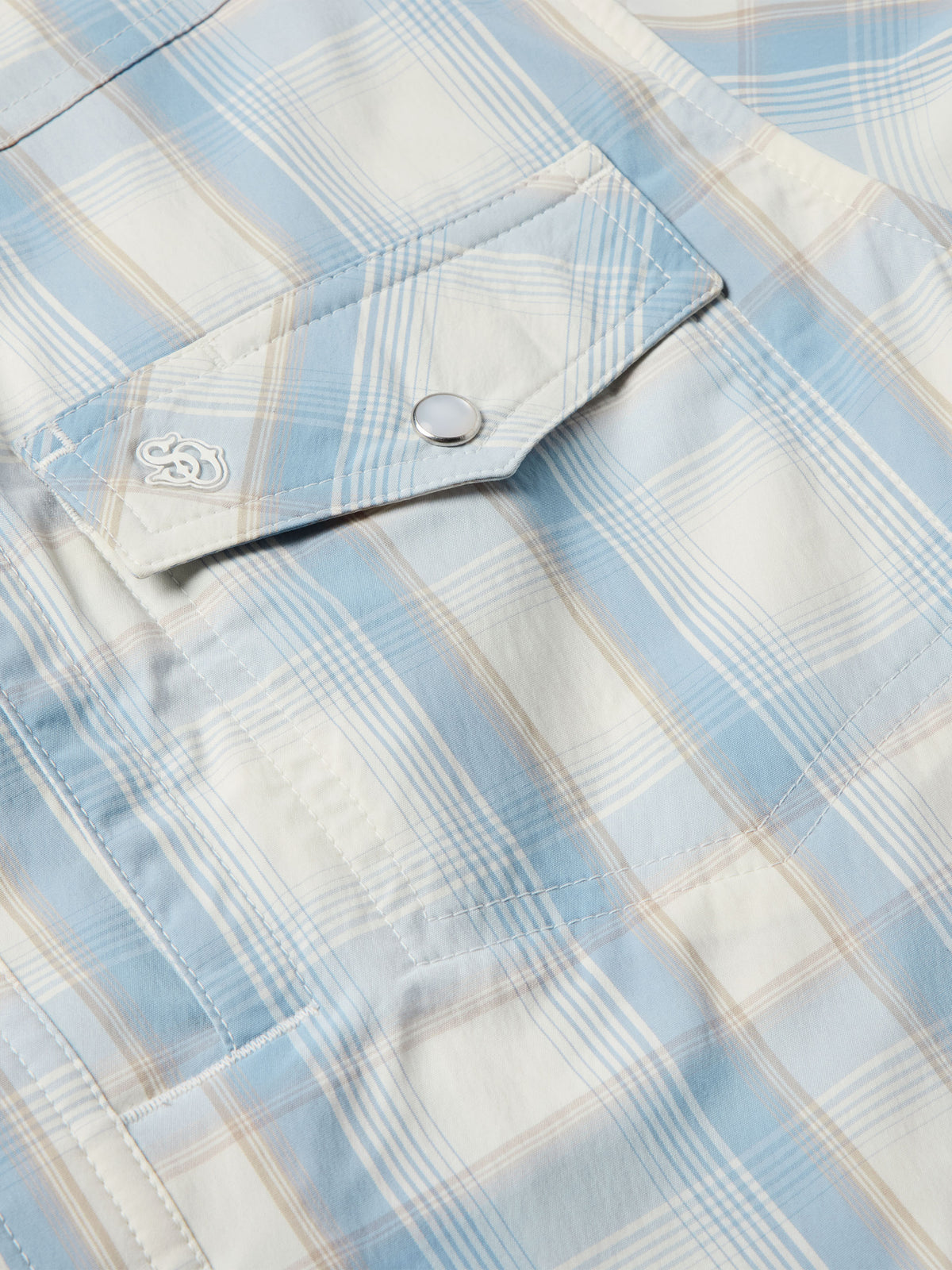 Light blue plaid western shirt shoulder yoke with embroidered emblem and snap