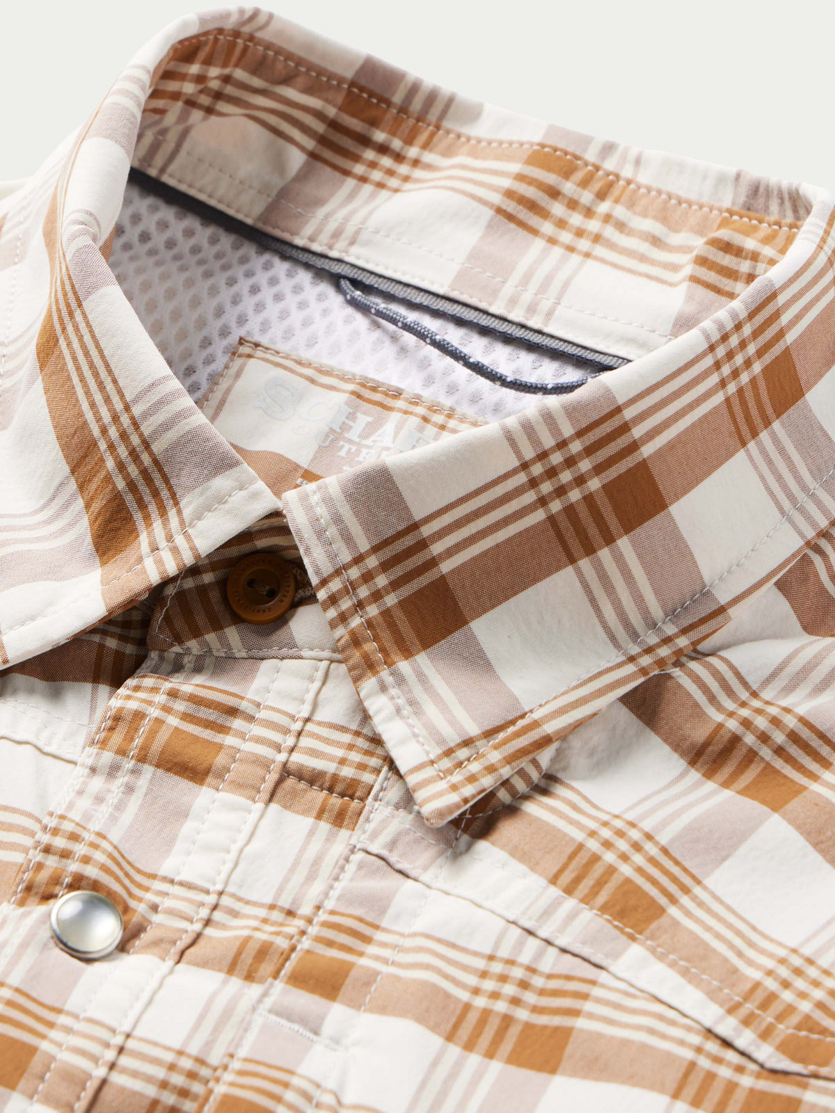 Western snap shirt collar and placket in tan-and-white plaid with snap and inner label.