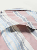 Close-up of men’s striped western snap shirt fabric with pink, blue, and white vertical stripes
