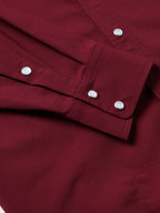 Maroon snap shirt cuff placket with silver buttons and tailored seams