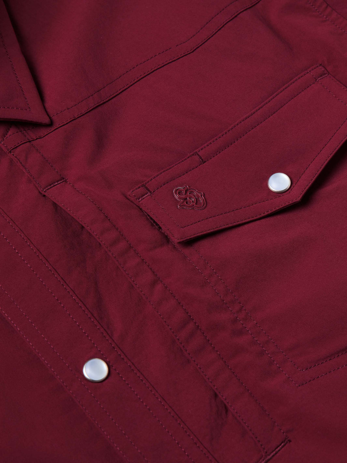 Maroon western shirt chest area with flap pocket and embroidered logo patch