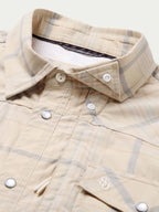 Snap shirt collar detail, cream with blue plaid, snap front and chest pocket stitching.