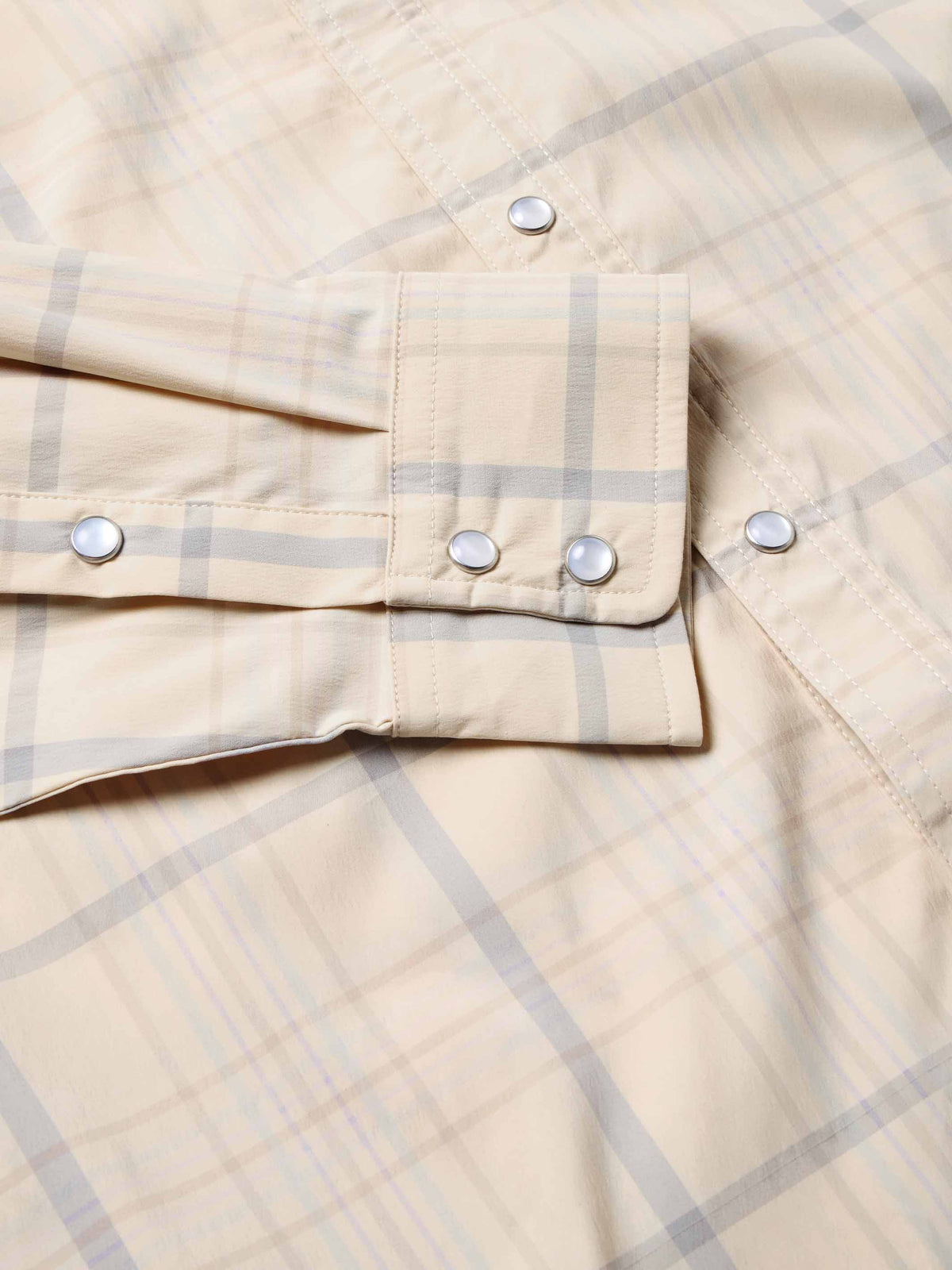 Snap shirt pocket and front placket detail, cream with blue plaid, snap tabs and buttons.