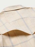 Tan plaid western snap shirt with curved yoke and snap-front placket