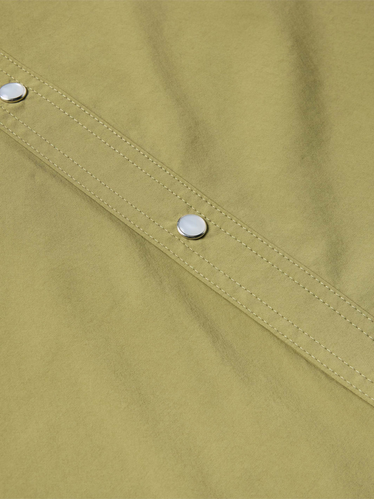 Olive short-sleeve snap western shirt close-up of button placket and stitched yoke