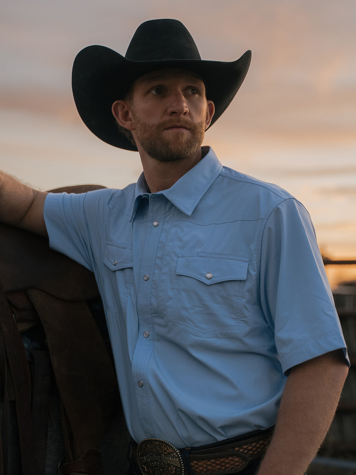 Sky blue short-sleeve snap western shirt with two chest pockets worn with hat