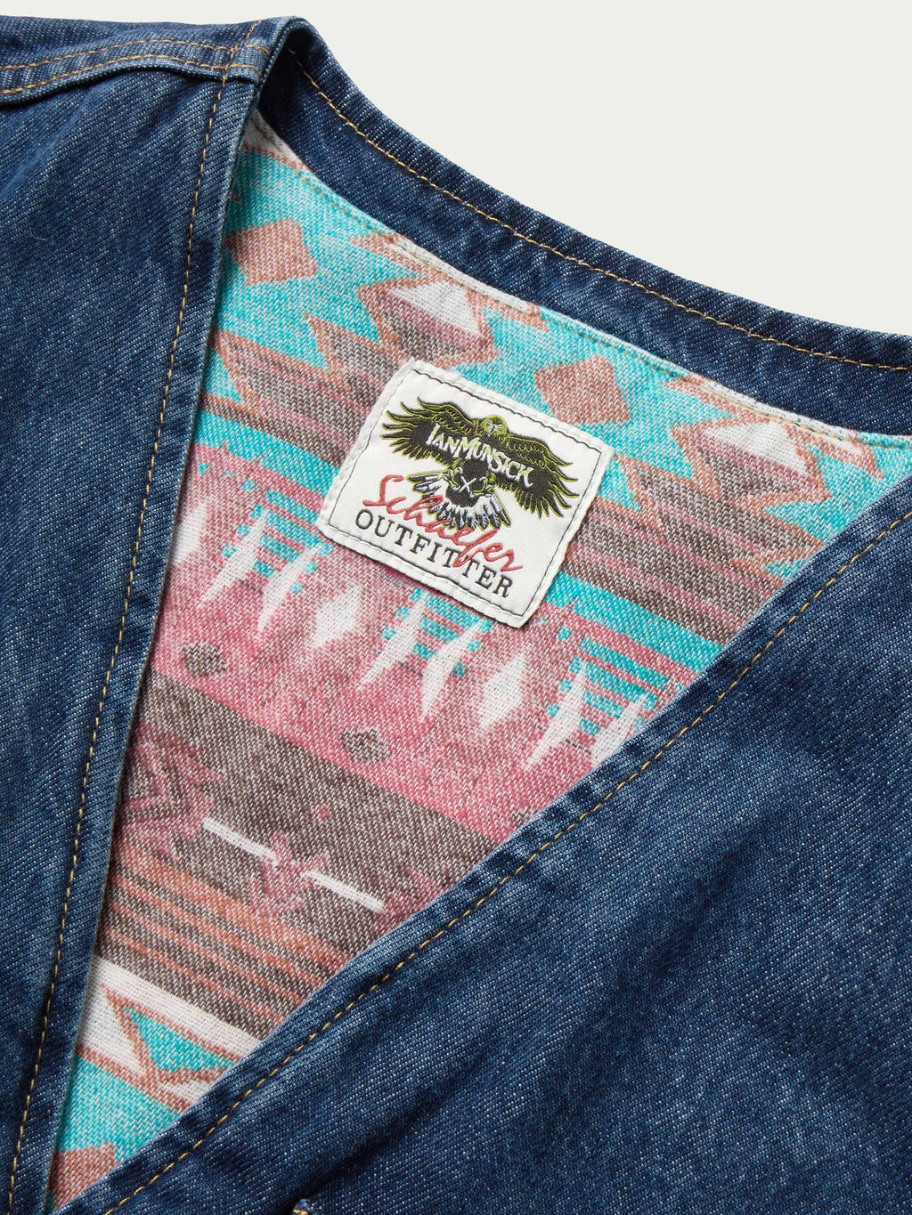 Denim vest interior tag on colorful patterned lining with button-front opening