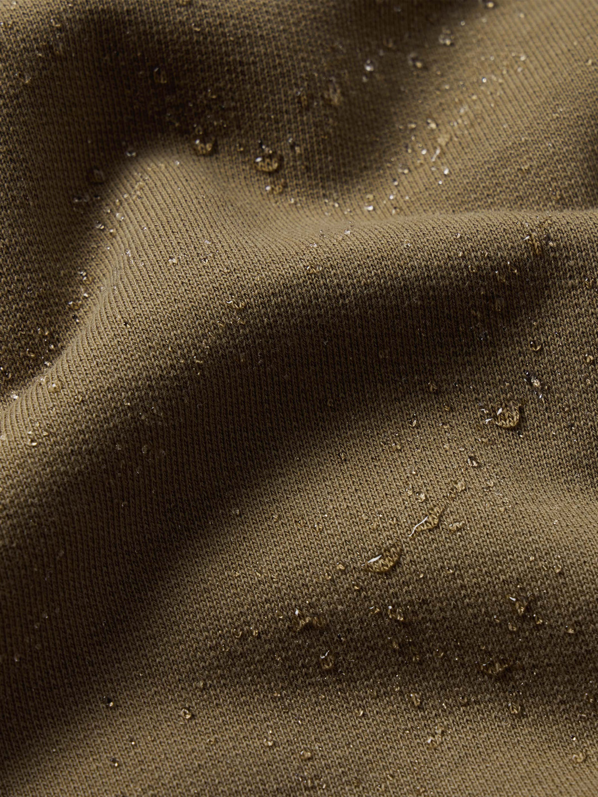 Olive speckled cotton hoodie fabric texture close-up